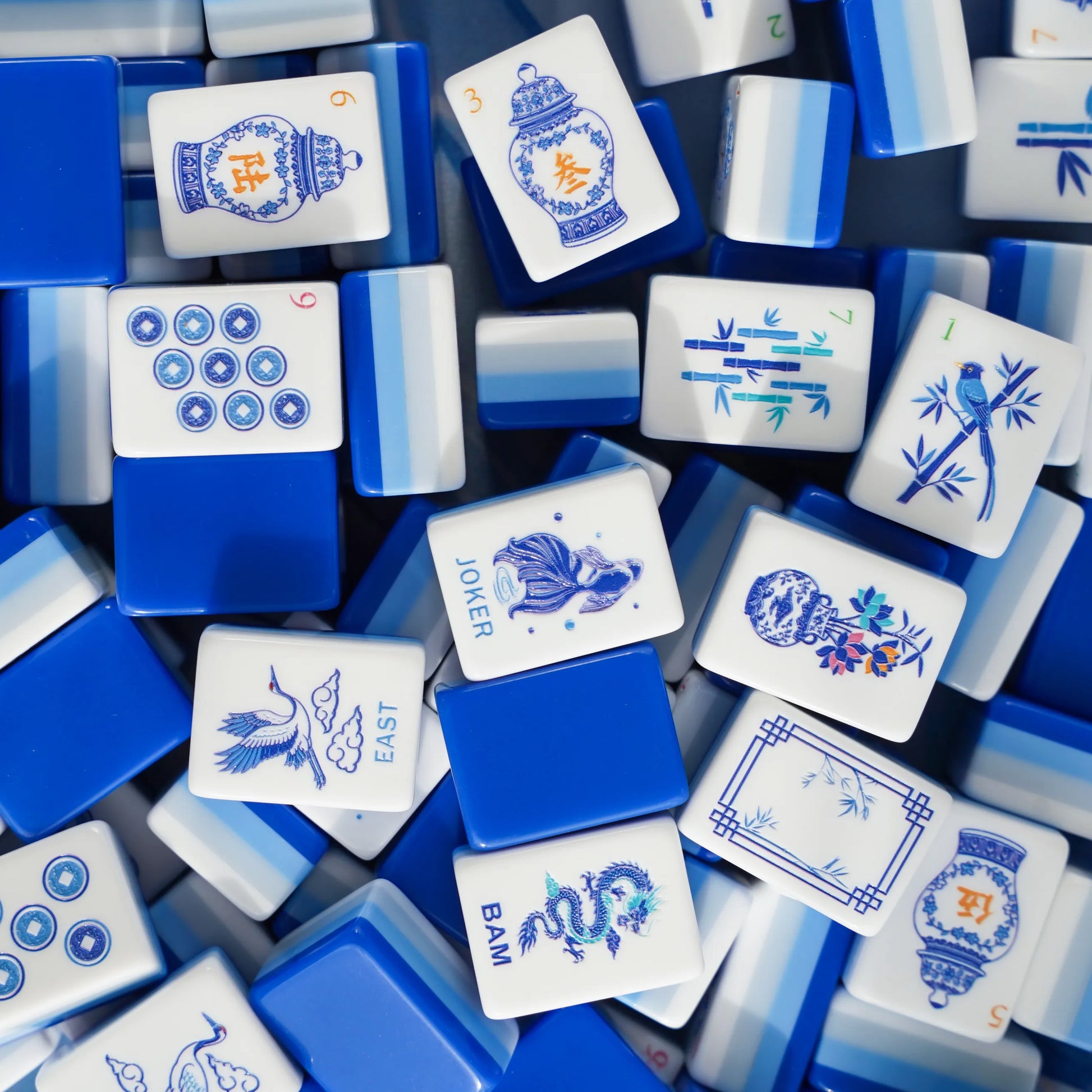 Full tile face layout of the Chinoiserie Porcelain American Mahjong set , displaying ginger jar characters, crane winds, fish jokers, and the cobalt blue triple-layer backing.