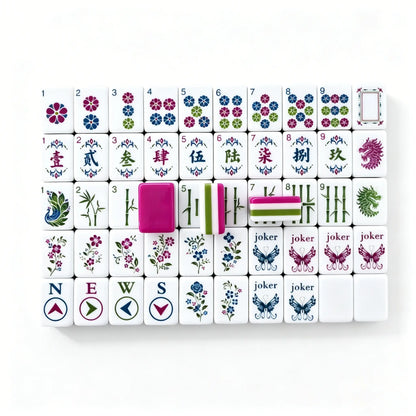 Full tile face layout of the Enchanted Butterfly Garden American Mahjong set, displaying compass winds, filigree crak characters, and a sample of the magenta triple-layer backing.