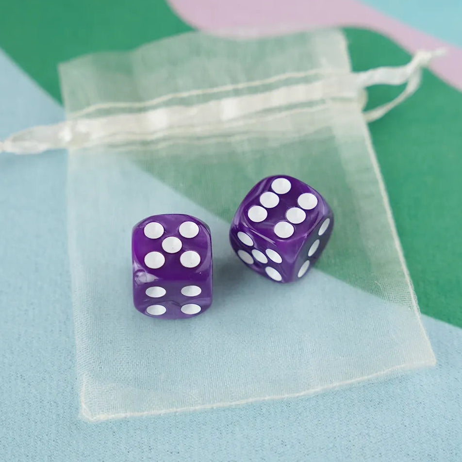 A pair of orchid purple 5/8 inch marbled acrylic mahjong dice with white pips in a sheer organza pouch.