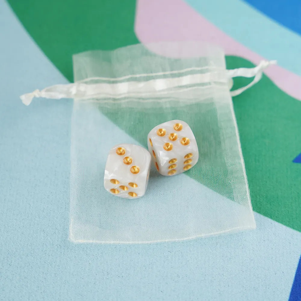 A pair of pearly white 5/8 inch marbled acrylic mahjong dice with gold pips in a sheer organza pouch.