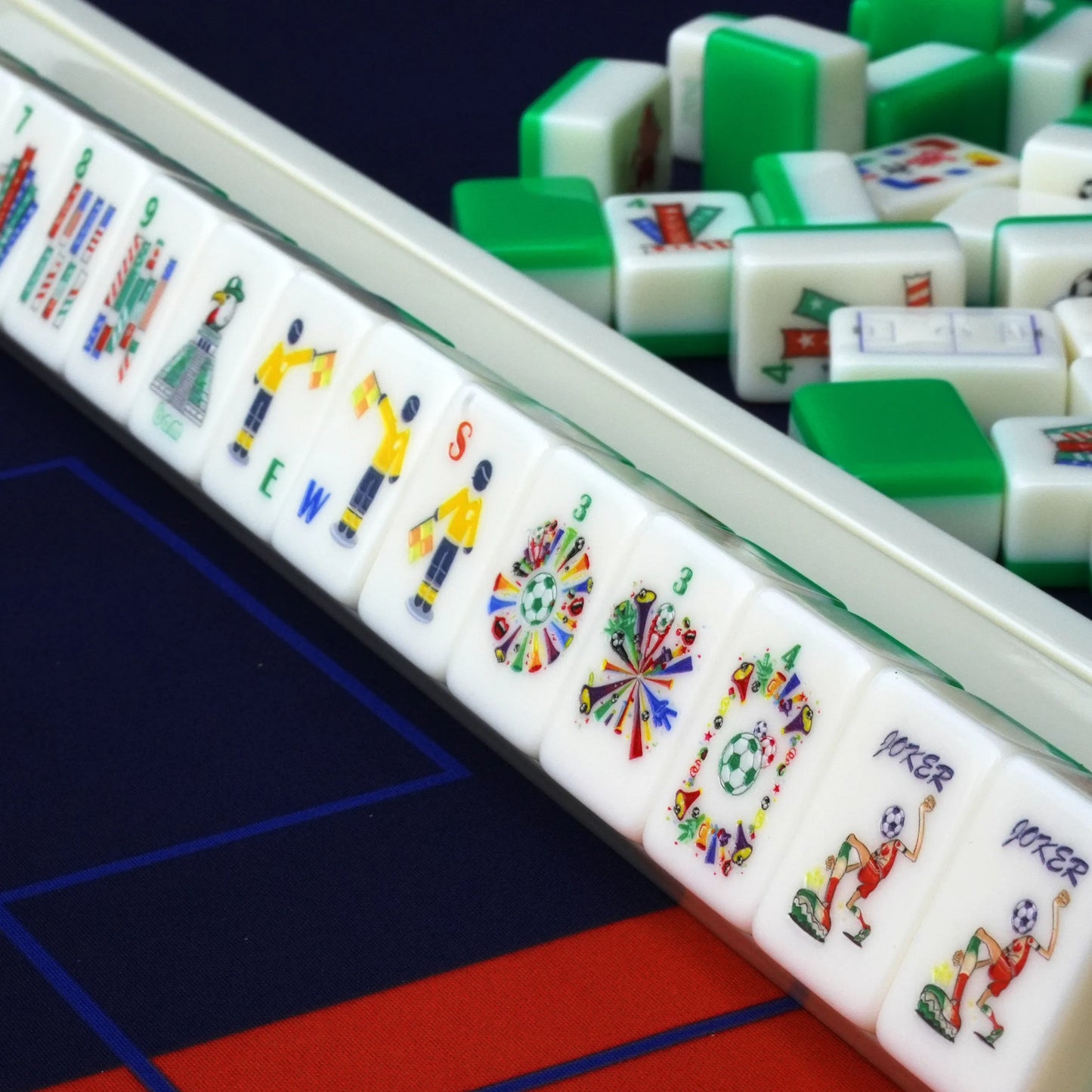 Side angle shot of sports themed Mahjong tiles on a rack showcasing referee winds, fan celebration flowers, and soccer jokers.