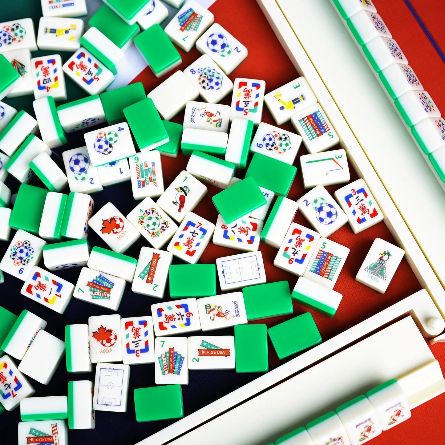 A jumbled pile of soccer themed American Mahjong tiles showing solid field-green backs mixed with referee winds and stadium flag bams.
